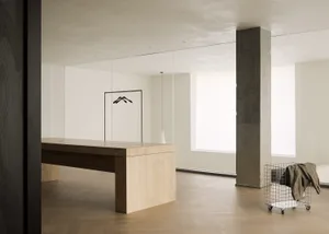 Modern minimalist living space featuring concrete, wooden, and metallic elements.
