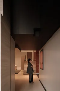 A person standing in a modern interior space with concrete walls and floors.