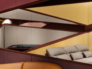 Modern leather couch with yellow walls and cushions.