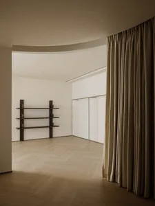 A minimalist interior design featuring wooden shelves, curtains, and metal railings.
