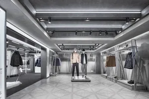 A modern retail display showcasing clothing items in a metallic setting.