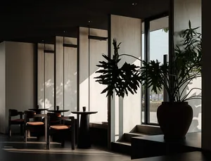 Minimalist cafe interior with concrete walls, wooden tables, and potted plants.