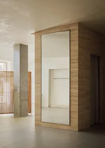A minimalist clothing studio with concrete walls and travertine tiles
