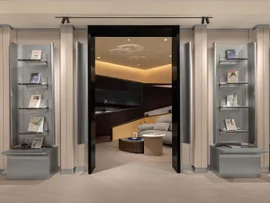 A modern office lounge features metal bookshelves and a comfortable seating area.
