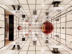 A modern retail space featuring marble and glass materials, with furniture and tables showcasing contemporary design.