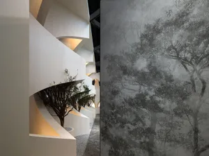 Modern staircase with white and concrete structures and a tree in a vase.