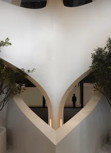 A modern interior space featuring concrete walls and archways.