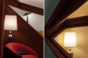 A modern interior design featuring a wooden staircase with a lamp and a red chair.