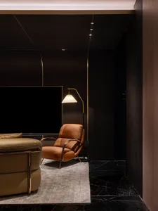 Modern living room with brown leather armchair and marble flooring.