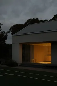 A modern residential exterior with metal cladding and lighting