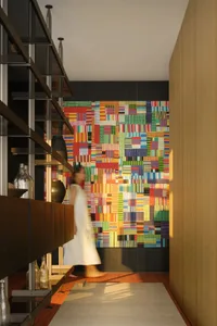A brightly colored, abstract wall mural in a modern entrance hall with a wooden floor and shelving unit.