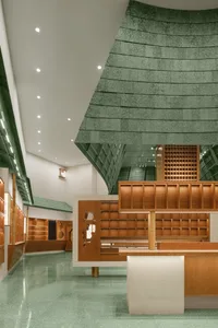 A modern bookstore with wooden features and a green, textured floor.