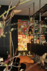 A modern dining room featuring mixed materials and colorful patterns.