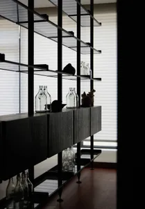 Modern minimalist bar with glass shelves and bottles arranged methodically.