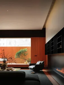 Modern minimalist living room featuring wood finishes and a sleek fireplace.