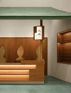 A modern retail store counter with wooden accents and green roofing.