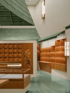 Modern retail space featuring wooden furnishings and textured green walls.