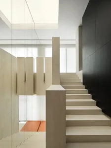 Minimalist interior design featuring modern concrete staircase with glass railings.