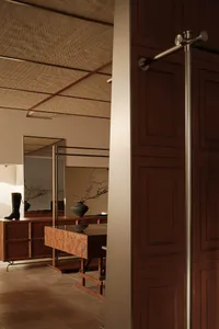 A modern clothing shop interior with wooden furniture, featuring a dressing table with a vase and a mirror on the wall.