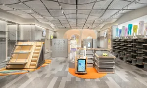 A modern retail store showcasing shelves and clothing with a focus on wood materials.