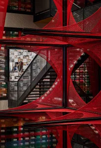 A red spider web installation in a modern interior space.