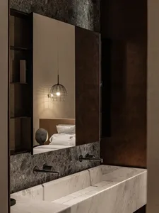 Modern bathroom with a white marble sink and a black wire pendant light hanging above a mirror.
