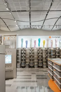 A modern retail space with metallic shelves and colorful leggings displayed on mannequin legs.