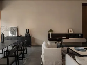 Modern living room with a minimalist design, featuring neutral-toned furniture and sleek, dark wood accents.