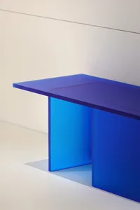 A minimalist glass furniture piece with a blue glass top and legs.
