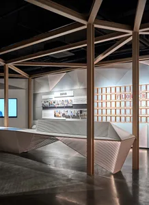 A minimalist exhibition space featuring metal installations and certificates on the wall.