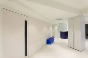 Modern minimalist office with white painted walls and floors, featuring sleek furniture and contemporary design.