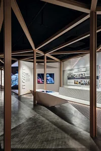A modern exhibition space with a white trench and neutral tones.