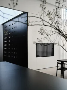 A minimalist black and white interior with a glass window and sleek, modern furniture.