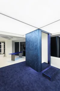A minimalist interior with concrete walls and blue accents.