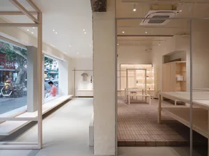 A minimalist retail shop featuring light-colored wood furnishings and a clean, uncluttered design.
