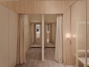 A modern fashion retailer clothing shop with shelves and mirrors.