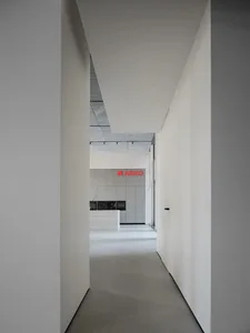 Modern minimalist office space with white walls and sleek design features.
