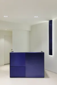 A sleek, metallic minimalist reception desk in a contemporary interior setting.