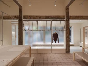 A modern retail storefront with glass walls, featuring minimalistic design elements and an industrial aesthetic.
