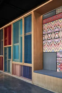 A wall display featuring multi-colored woven textiles with decorative patterns and textures.