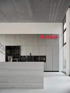 Modern, sleek, and industrial commercial kitchen with metallic and glass materials, featuring ASKO branded appliances.