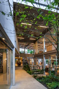 A modern commercial space with a metal staircase and greenery.