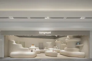 Modern minimalist retail storefront with white, curved furniture and signage for Songmont.