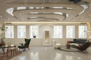A modern lobby with a concrete floor, glass walls, and wooden elements.