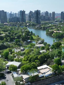 俯瞰城市景觀，現代高樓大廈與茂密綠地及水道交織。