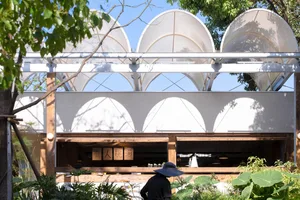 Modern cafe exterior with metal, glass, and wooden structural elements.