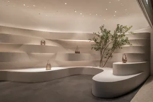 A modern retail store interior featuring concrete shelves and a tree.