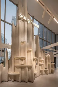 A modern retail interior featuring concrete shelves displaying handbags.