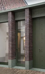 現代建築外觀，搭配磚柱、玻璃門及混凝土裝飾細節。