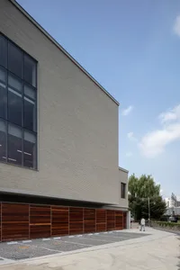 Modern minimalist building exterior with large glass windows and brick walls.